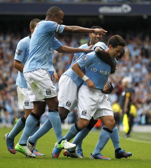 Manchester City's French player Samir Nasri (R) celebrates with teammates after scoring a goal