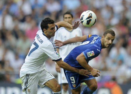 Real Madrid defender Alvaro Arbeloa (R) fights for the ball with Valencia&#039;s forward Roberto Soldado (L)