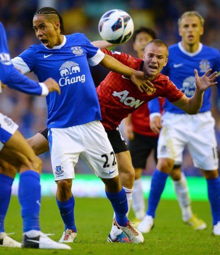 Everton&#039;s midfielder Steven Pienaar (L) vies for the ball with Manchester United&#039;s midfielder Tom Cleverley