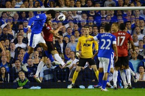 Everton's Belgian midfielder Marouane Fellaini (L) heads the opening goal