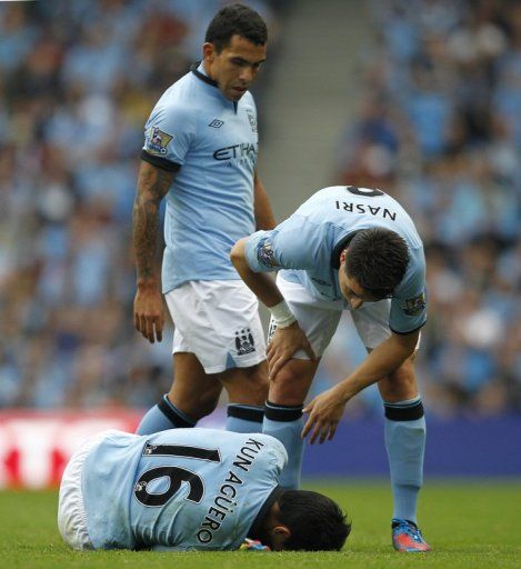 Manchester City&#039;s French player Samir Nasri (R) checks on Manchester City&#039;s Argentinian player Sergio Aguero