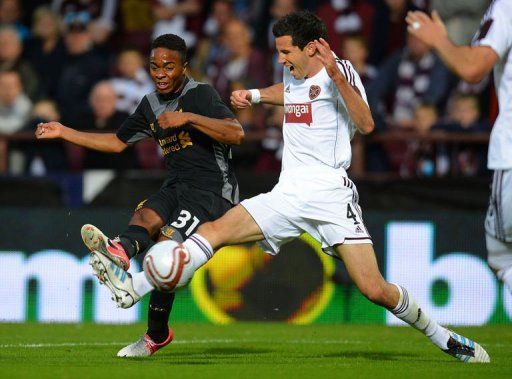 Liverpool&#039;s English midfielder Raheem Sterling (L) shoots past Hearts&#039; Australian defender Ryan McGowan