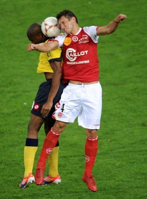 Reims' midfielder Grzegorz Krychowiak (R) jumps for the ball with Sochaux' forward Sloan Privat