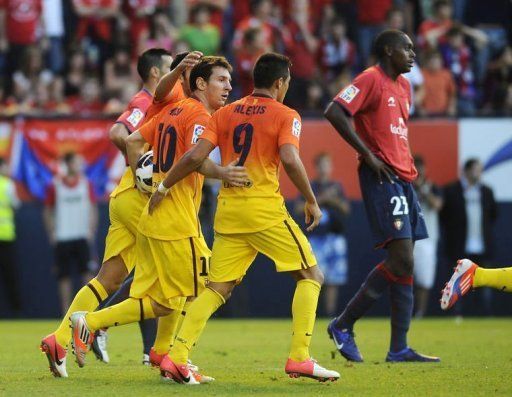 FC Barcelona&#039;s players congratulate Barcelona&#039;s Argentinian forward Lionel Messi (2nd L) on scoring against Osasuna