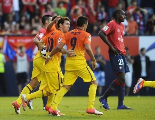 FC Barcelona's players congratulate Barcelona's Argentinian forward Lionel Messi (2nd L) on scoring against Osasuna