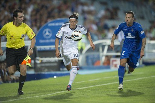 Real Madrid&#039;s Mesut Ozil (C) vies with Getafe&#039;s Alexis