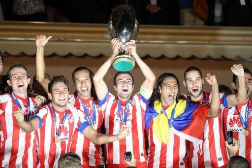 Atletico Madrid&#039;s players celebrate with the trophy