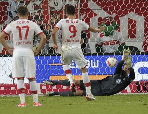 Wolfsburg's Swiss goalkeeper Diego Benaglio (R) saves a penalty shot of Stuttgart's Vedad Ibisevic