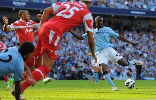 Manchester City&#039;s midfielder Yaya Toure (R) scores the opening goal