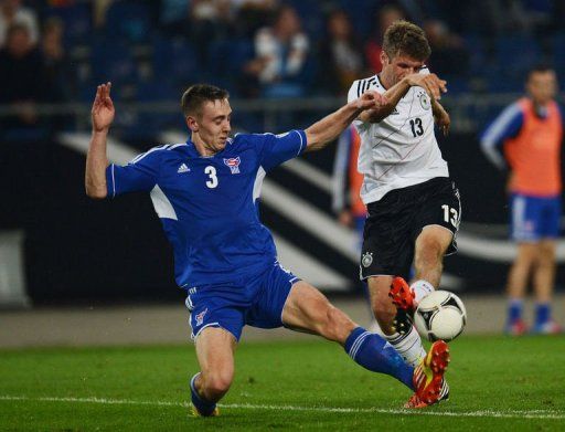 Germany&#039;s midfielder Thomas Mueller (R) clashes with Faroe&#039;s defender Pol Johannus Justinussen