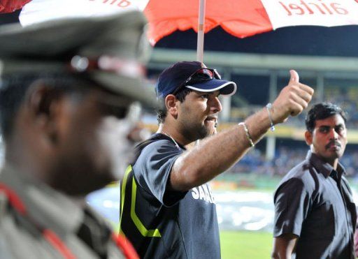 Indian cricketer Yuvraj Singh acknowledges the crowd during heavy rain