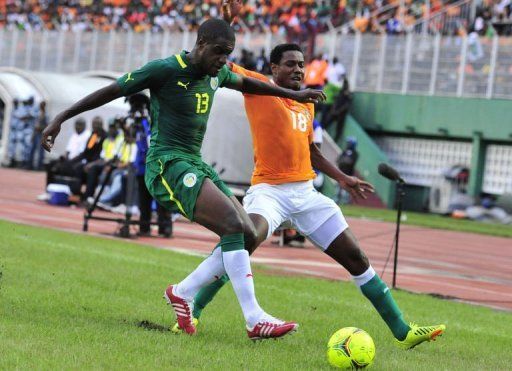 Ivory Coast&#039;s Kader Keita (R) fights for the ball with Senegal&#039;s Jacques Doudou Faty