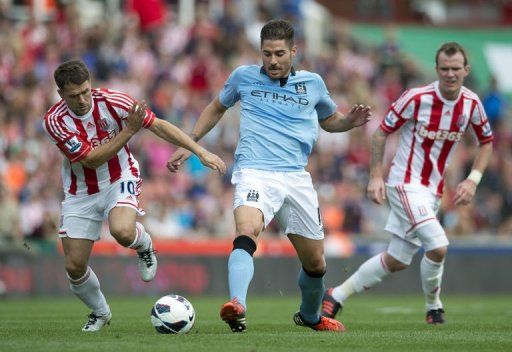 Stoke City&#039;s Michael Owen (L) clashes for the ball with Manchester City&#039;s Javi Garcia (C)