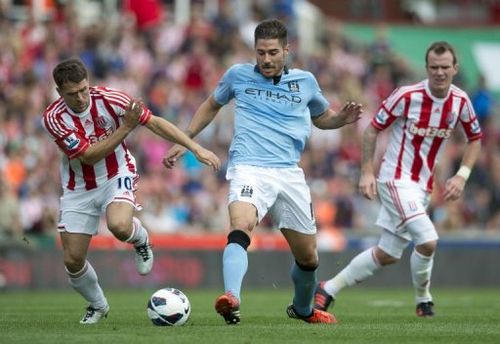 Stoke City's Michael Owen (L) clashes for the ball with Manchester City's Javi Garcia (C)