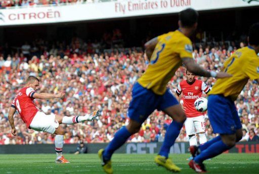 Arsenal&#039;s striker Lukas Podolski (L) scores