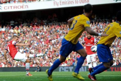 Arsenal's striker Lukas Podolski (L) scores