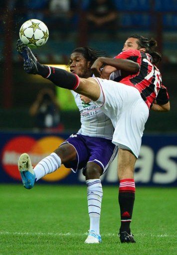 Anderlecht&#039;s forward Dieumerci Mbokani (L) fights for the ball with AC Milan&#039;s Mario Yepes