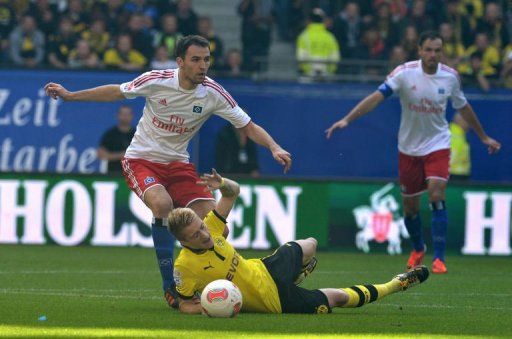 Hamburg&#039;s midfielder Milan Badelj (L) and Dortmund&#039;s striker Marco Reus (C) fight for the ball