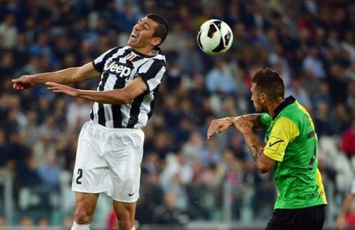 Juventus' defender Lucio (L) jumps for the ball over Chievo's forward Cyril Thereau