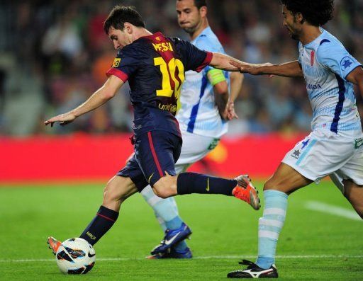 Barcelona&#039;s forward Lionel Messi (L) shoots to score