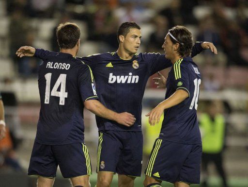 Real Madrid&#039;s Cristiano Ronaldo (C) celebrates with Xabi Alonso (L) and Mesut Ozil