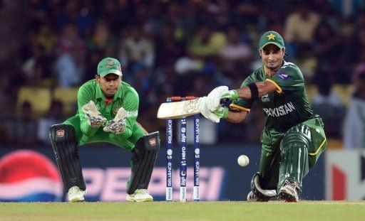 Bangladesh&#039;s wicket keeper and captain Mushfiqur Rahim (L) watches as Pakistan&#039;s batsman Imran Nazir plays a shot