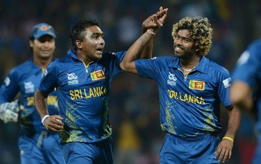 Lasith Malinga (right) and captain Mahela Jayawardene celebrate the wicket of New Zealand&#039;s Martin Guptill