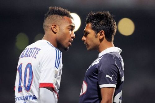 Lyon's Alexandre Lacazette (L) clashes with Bordeaux's Benoit Tremoulinas