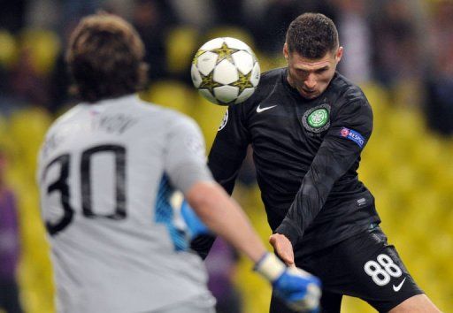 Celtic&#039;s Gary Hooper (R) heads the ball as Spartak&#039;s Moskva goalie Sergei Pesyakov (L) tries to stop