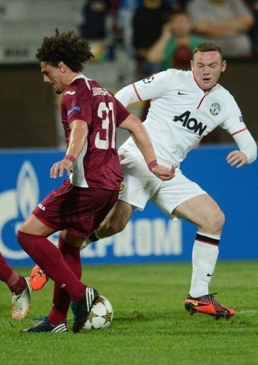 Manchester United&#039;s Wayne Rooney (R) and Cluj&#039;s Matias Aguirregaray