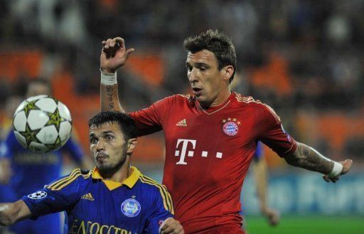 BATE Borisov&#039;s Marko Simic (L) fights for the ball against Bayern Munich&#039;s Mario Mandzukic