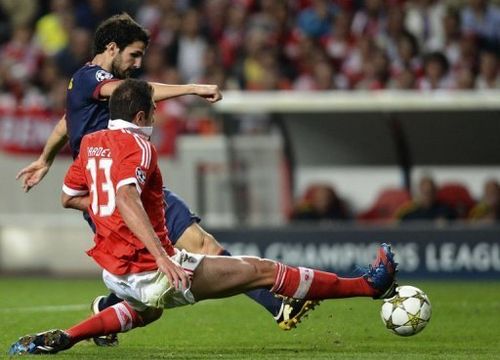 Barcelona's Cesc Fabregas (L) kicks the ball past Benfica's Jardel Vieira to score