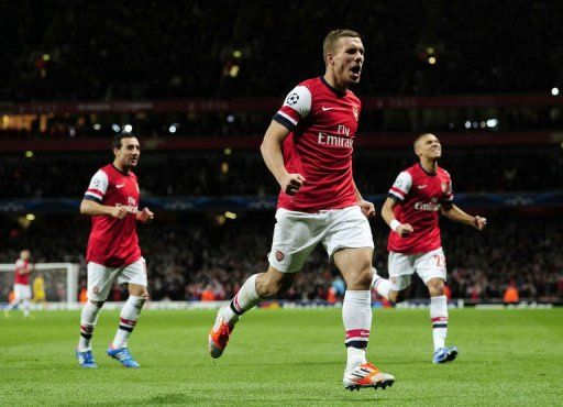 Arsenal&#039;s Lukas Podolski (C) celebrates scoring