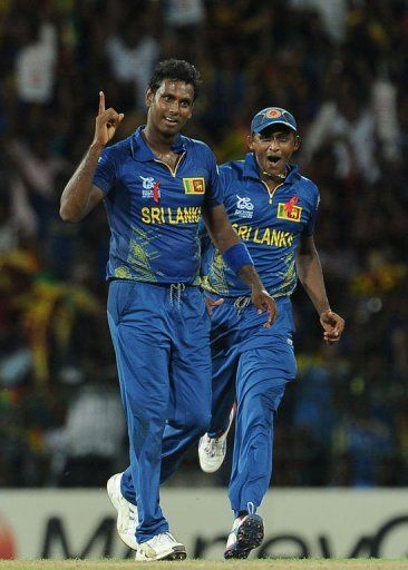 Sri Lankan cricketer Angelo Mathews (L) celebrates with teammate Ajantha Mendis