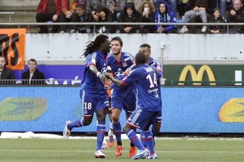 Lyon's Bafetimbi Gomis (L) celebrates with teammates after scoring