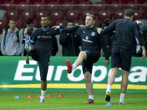 England&#039;s defender Ashley Cole (left) and forward Wayne Rooney (C) take part in a trainning session