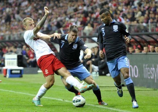 England&#039;s James Milner (C) and Ashley Cole vie for the ball with Poland&#039;s Kamil Grosicki (L)