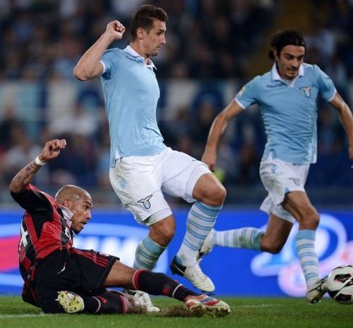 AC Milan's midfielder Nigel de Jong (L) slides to score against Lazio