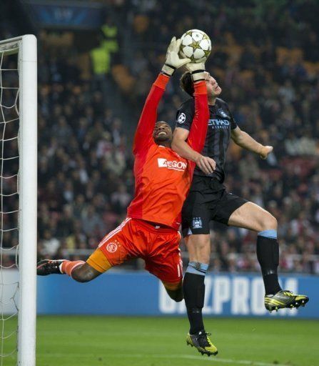 AFC Ajax&#039;s goalkeeper Kenneth Vermeer (L) vies for the ball against Manchester City&#039;s Edin Dzeko