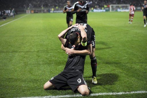 Lyon&#039;s Lisandro Lopez (down) is congratulated by Anthony Reveillere after scoring