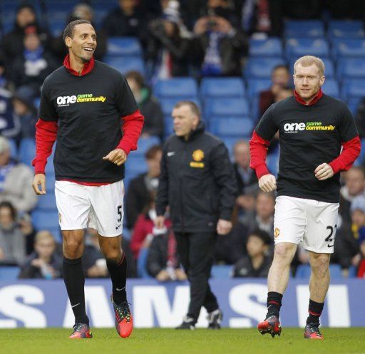 Rio Ferdinand (L) warms up with Paul Scholes (R), both wearing the T-shirt from Kick It Out