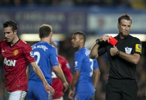 Referee Mark Clattenburg (R) puts his red card away after sending off Chelsea&#039;s Branislav Ivanovic (2nd L)