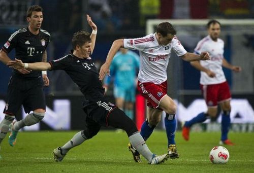 Bayern Munich's midfielder Bastian Schweinsteiger (L) and Hamburg's midfielder Marcell Jansen fight for the ball