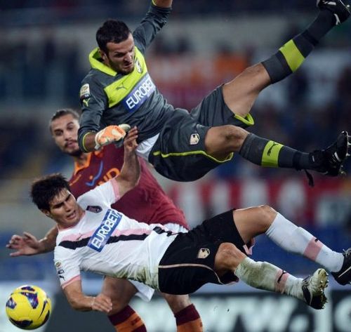 Palermo's Samir Ujkani (R) and Ezequiel Munoz (L) fight for the ball with AS Roma's Pablo Daniel Osvaldo (C)