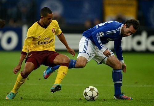 Schalke's Christian Fuchs (R) and Arsenal's Theo Walcott fight for the ball