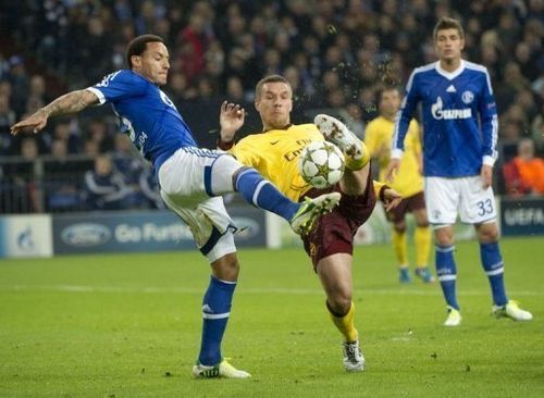 Arsenal's Lucas Podolski (C) and Schalke's Jermaine Jones (L) fight for the ball