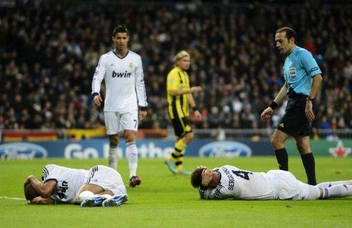 Real Madrid&#039;s Pepe (L) and Sergio Ramos lie on the ground after being injured