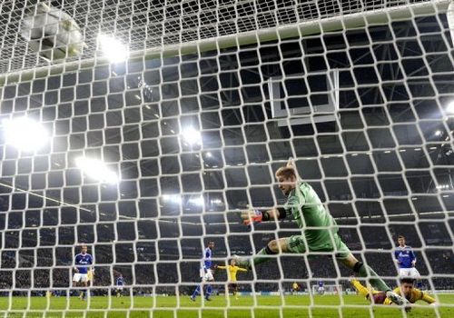 Arsenal's Olivier Giroud (R) heads past Schalke's goalkeeper Lars Unnerstall to score