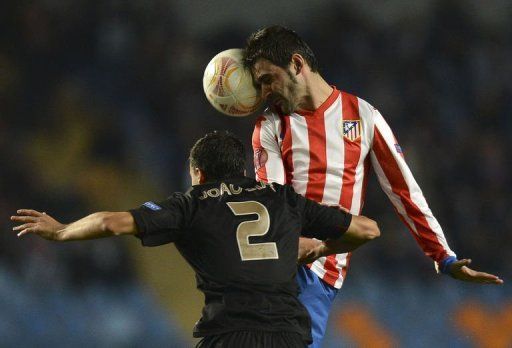 Atletico Madrid&#039;s Adrian Lopez (R) vies with Academica&#039;s Joao Dias