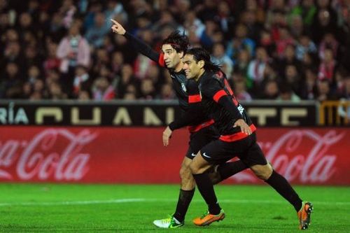 Atletico Madrid's Arda Turan (L) celebrates with Radamel Falcao (R) after scoring